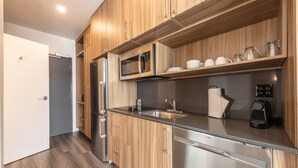 A modern kitchen with wooden cabinets, stainless steel appliances, and a built-in microwave.