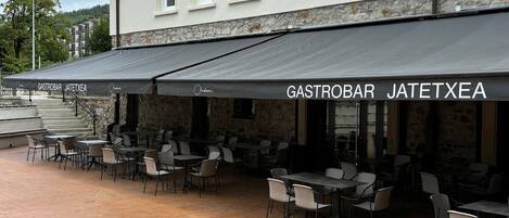 Un restaurante llamado "Gastrobar Jatetxea" con terraza y fachada de piedra.