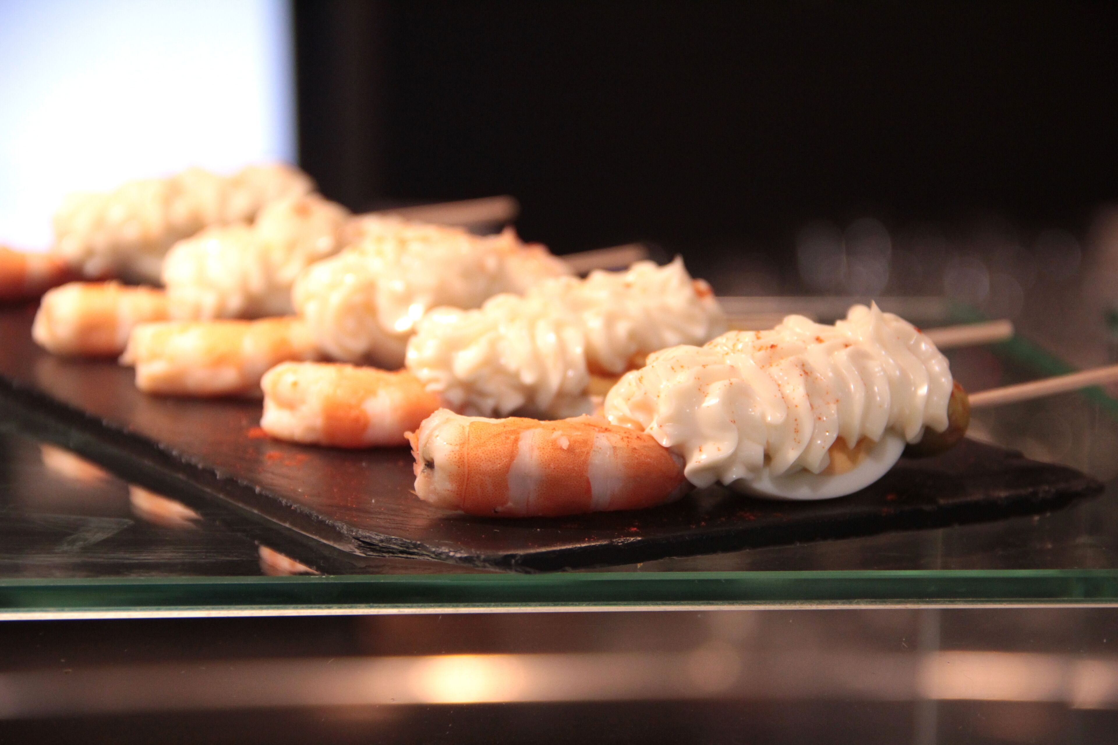 Una bandeja de sushi sobre una mesa de vidrio.