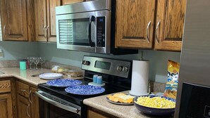 A kitchen with wooden cabinets, stainless steel appliances, and a granite countertop. - Crystal River Condo -Near Three Sisters and Hunters Spring (Crystal River)