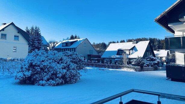 A residential area with snow-covered houses and a clear blue sky. - Sunside vacation apartment in the heart of Winterberg (Winterberg)