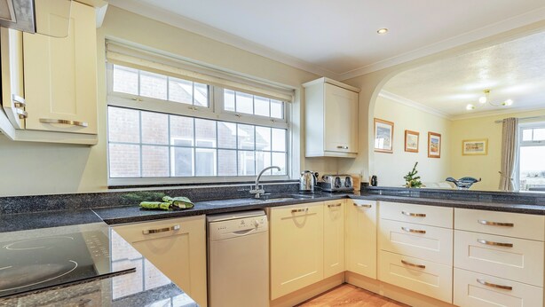 A modern kitchen with a dishwasher, a stove, and a sink. - Spacious property and stunning sea views in great location. (Greatstone)