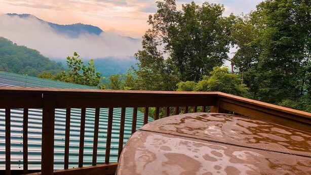 A wooden deck with a view of a lake and mountains.