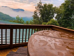 Une terrasse en bois offrant une vue sur un lac et des montagnes.
