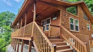 A wooden cabin with a porch, a staircase, and a sign indicating a private road.