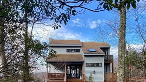 A two-story house with a front porch, a covered entryway, and a small deck. - Cozy Cottage with beautiful Mountain View’s - close to wineries (Wintergreen Resort)