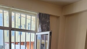 Una camera da letto con un letto, una finestra con le sbarre e vista sull'esterno.