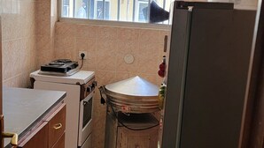 Una cucina compatta con una finestra, un frigorifero, un forno e un lavello.