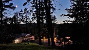 A cabin surrounded by tall trees with a clear sky and a visible moon. - Waterfront cottages near lake george and saratoga springs (Lake Luzerne)