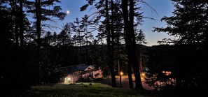 A cabin surrounded by tall trees with a clear sky and a visible moon. - Waterfront cottages near lake george and saratoga springs (Lake Luzerne)