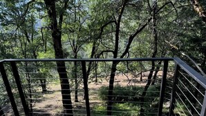 A wooden deck with a metal railing overlooking a forested area. - Beautiful Mountain Getaway with amazing views (Loch Lomond)