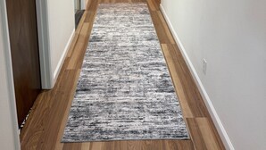 A hallway with wooden flooring, a gray rug, a bench, and a framed picture on the wall. - Beautiful Mountain Getaway with amazing views (Loch Lomond)
