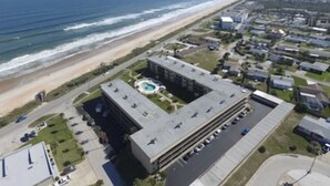 Un grand bâtiment doté d’une piscine, situé près d’une plage.