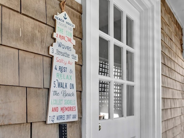 A wooden sign with a list of activities near a white door.