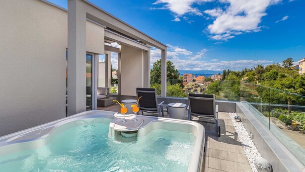 A rooftop terrace with a hot tub, seating area, and a view of the city. - Modern villa MODERNA with heated pool, hot tub and sauna (Malinska)