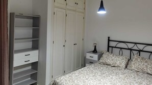 A bedroom with a bed, a wardrobe, and a bedside table. - San Fernando, Cadiz  (San Fernando)