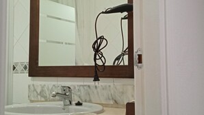A bathroom with a large mirror, a sink, a towel rack, and a door. - San Fernando, Cadiz  (San Fernando)