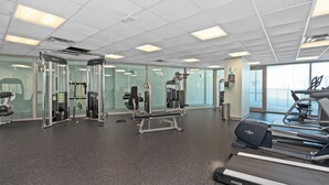 A gym with cardio machines, weight training equipment, and a mirrored wall. - Coveted Gulf-front condo on pool deck, directly on beach, no highway to cross! (Biloxi)