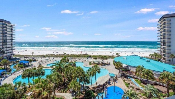 Un resort con varias piscinas, playa y vistas al océano.