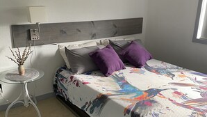 Makuuhuone, jossa on sänky, yöpöytä, lamppu ja ikkuna.