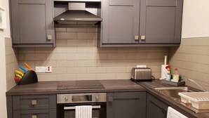 A modern kitchen with grey cabinets, a built-in oven, a toaster, and a sink. - # 5 Central Killarney Apartment (KILLARNEY)