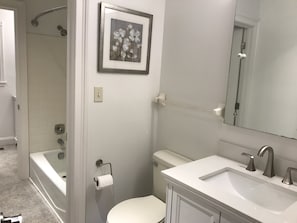 A bathroom with a bathtub, toilet, sink, and a framed picture on the wall. - Private home only 12 minutes from the heart of Asheville. (Asheville)