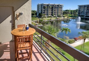 Enjoy a peaceful view from this balcony overlooking a serene pond and fountain.