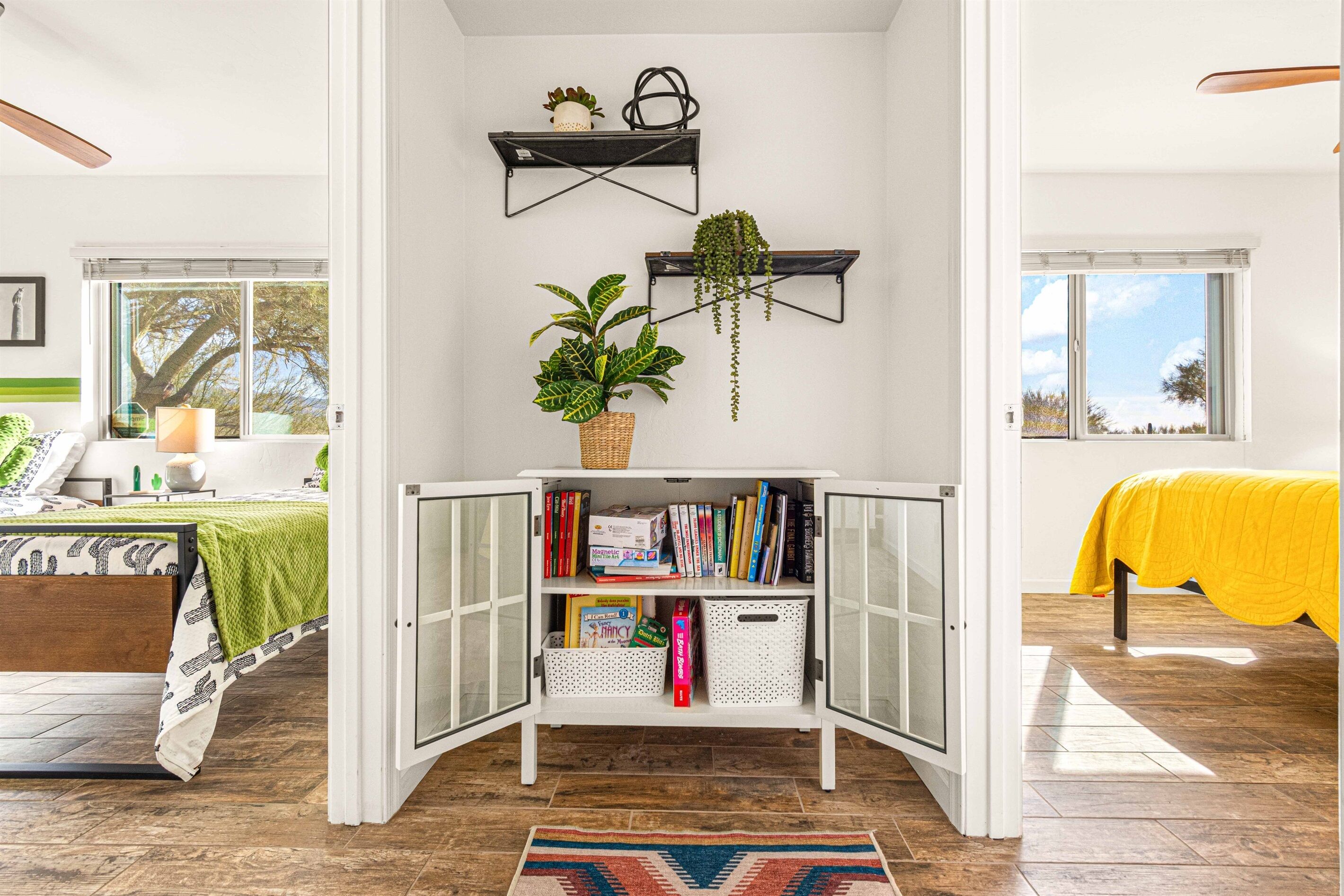 Habitació amb un llit, una biblioteca i una finestra que dona a una vista.