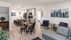 Un appartement moderne comprenant un coin repas, une cuisine et un salon.