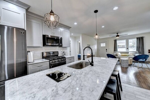 Enjoy cooking in this well-equipped kitchen with a gas stove, microwave, and refrigerator, plus a large window offering a city view.