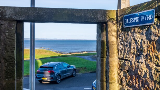 A car parked at the entrance of a coastal area with a sign reading "Gillespie Wynd". - Superbly located St Andrews 2 bedroom apartment.  Beach and golf close by! (St Andrews)