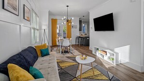 A modern living room with a sofa, coffee table, and a TV mounted on the wall.