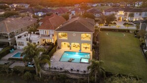 Une grande maison avec une piscine, plusieurs chambres et une pelouse bien entretenue.