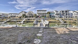 A waterfront property with multiple buildings, a dock, and a pathway leading to the water. - Steps to Sunset Beach: Canal-Front Home w/ Dock! (Sunset Beach)