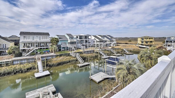 A waterfront property with multiple buildings, docks, and a calm water body. - Steps to Sunset Beach: Canal-Front Home w/ Dock! (Sunset Beach)