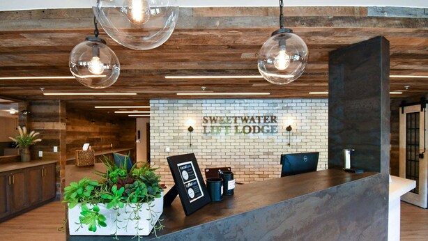 Un comptoir d’accueil avec une pancarte indiquant : « Sweetwater Lift Lodge ».