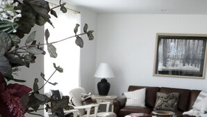 A dining area with a long table, chairs, a lamp, and a painting on the wall. - Historic ranch house has beautiful mountain and valley views. Weekly discounts. (Manhattan)