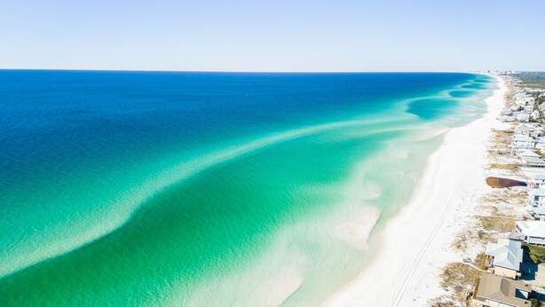 An aerial view of a coastal area with a beach and residential buildings along the shore. - Luxurious 4-BR Home w/ Private Pool & Beach Access – Golf Cart & Bikes Included (Santa Rosa Beach)