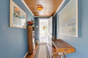 A hallway with blue walls, wooden ceiling, framed artwork, a wicker basket, and a door leading outside. - < 3 Mi to Golf & Swim: Cozy Oasis in Lake Worth! (Lake Worth)