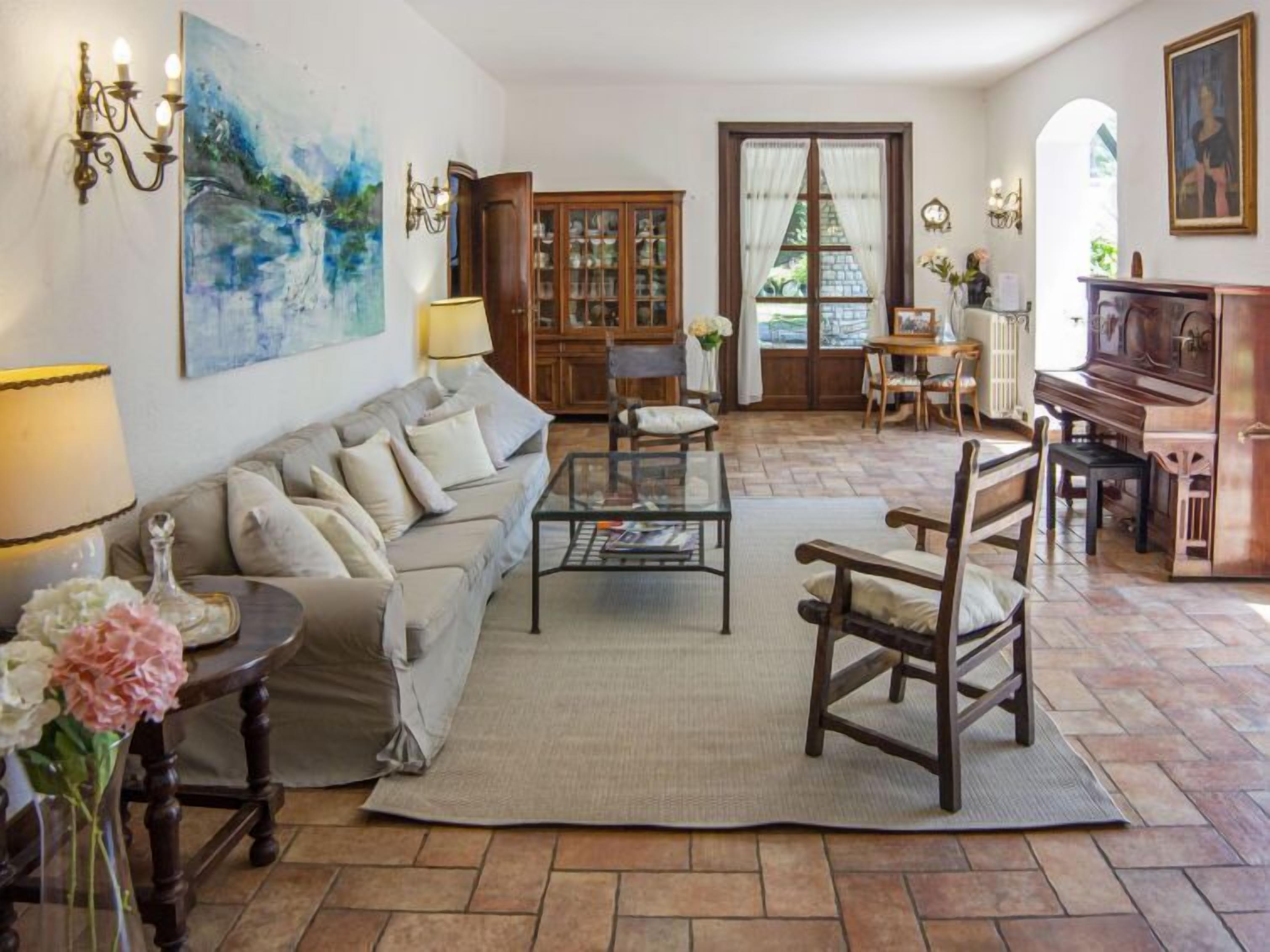 Un salon avec un canapé, une table basse et un piano.