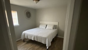 A bedroom with a bed, a clock on the wall, and a window. - 3.2 miles to the beaches and Bay, Cute Florida Cottage (Fort Walton Beach)