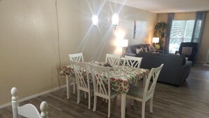 Ein Essbereich mit Tisch, Stühlen, einer Couch und einer Lampe.