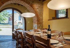 A dining table set with chairs, a bottle of wine, and glasses.