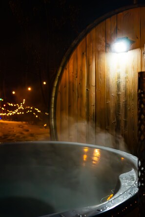 A hot tub with steam rising from the water, surrounded by wooden walls and a light source above. - Lake Life(Waterfront) (Seven sisters falls)