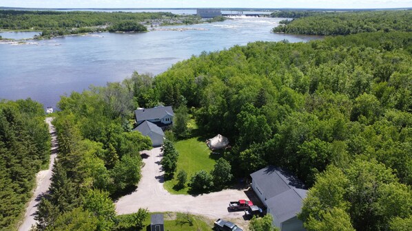 An aerial view of a residential area with houses, a river, and a bridge. - Lake Life(Waterfront) (Seven sisters falls)