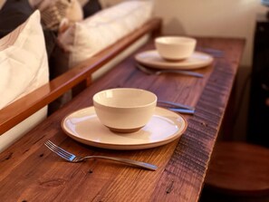 A wooden dining table with two bowls and cutlery. - Small cabin on private 400 acre mountaintop farm! (Hinton)