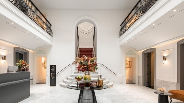 A spacious lobby with a central round table, a reception desk, and a staircase leading to an upper level. - Áurea Casa Palacio Sagasta By Eurostars Hotel Company (Cádiz)
