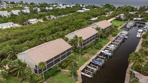 A marina with boats docked, surrounded by lush greenery and residential buildings. - Waterfront condo located in the waterfront paradise of Bokeelia (Bokeelia)