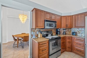 Enjoy cooking in this well-equipped kitchen with a stainless steel range, microwave, and dining table.