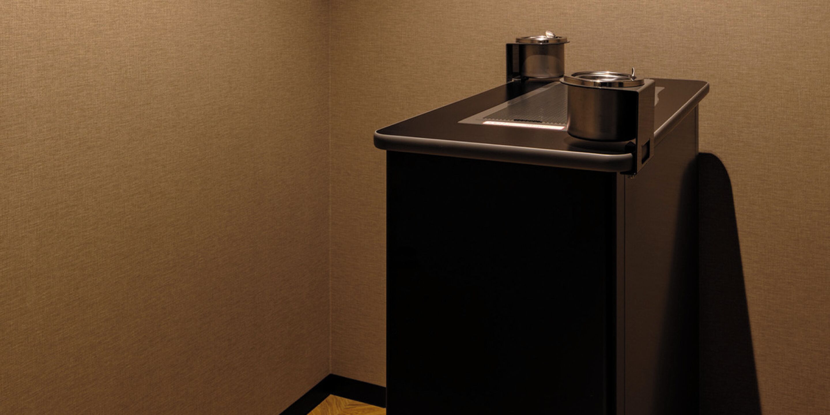 A compact, modern kitchenette with a built-in coffee maker and a small sink.